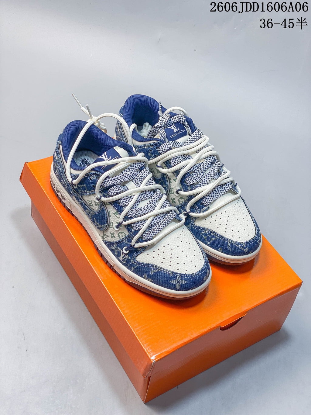 Pair of blue and cream patterned low-top sneakers with layered white laces on an orange box