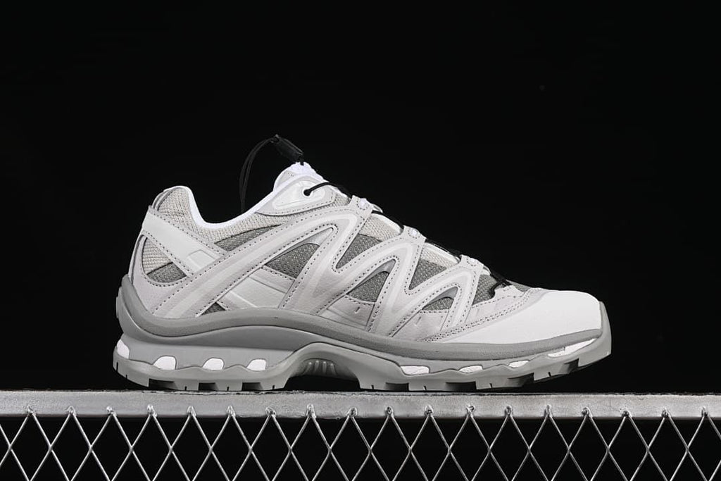 Outer side profile of a gray and white sneaker