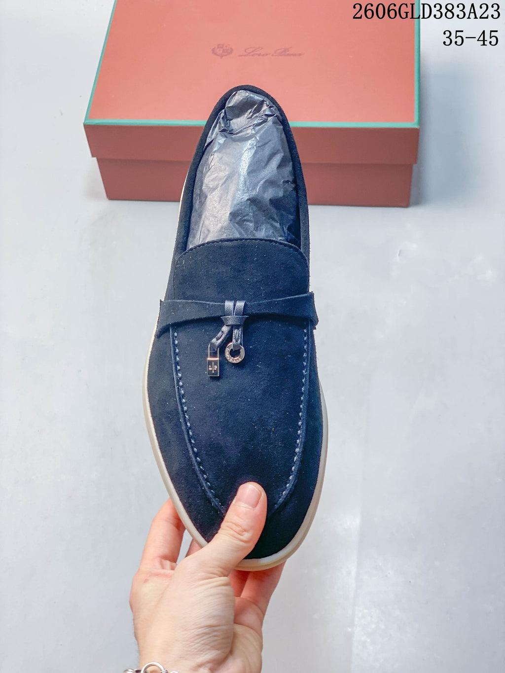 Top view of a navy loafer with a strap and metal accents