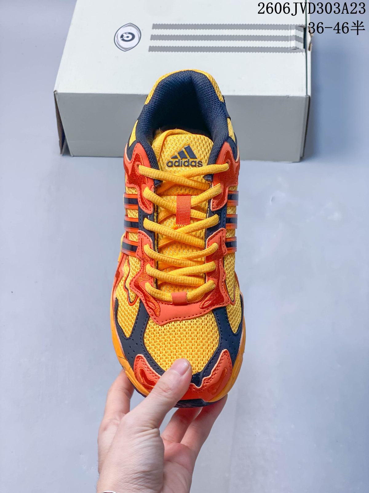 Top view showing the yellow mesh-like panels, orange overlays, and laces