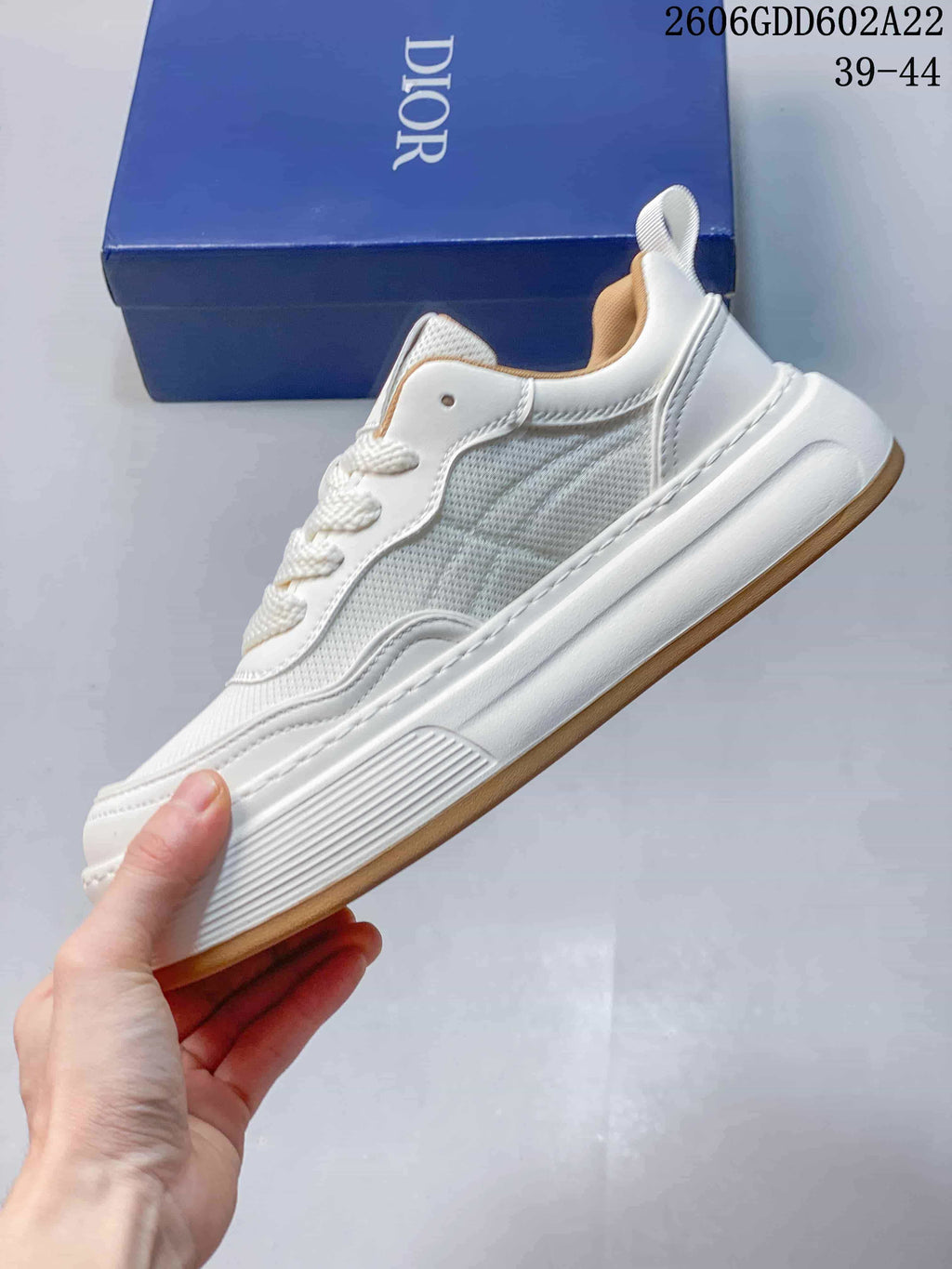 Side profile of a white mesh-panel sneaker with layered stitching
