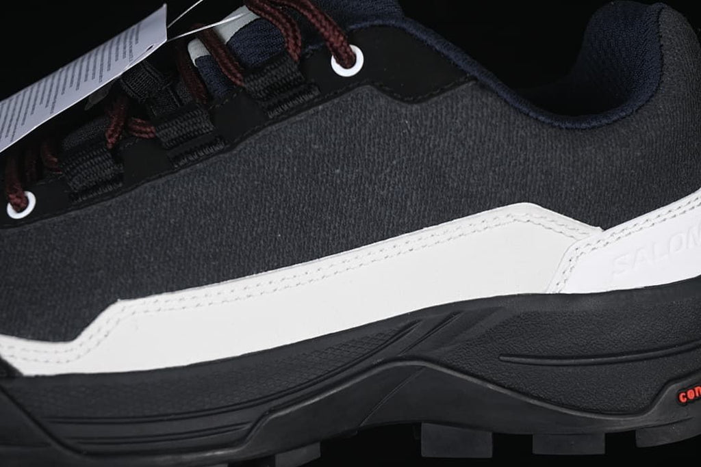 Close-up of the black upper, white side panel, laces and outsole.