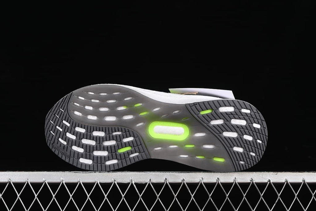 Underside view showing the patterned dark outsole with light and lime details.