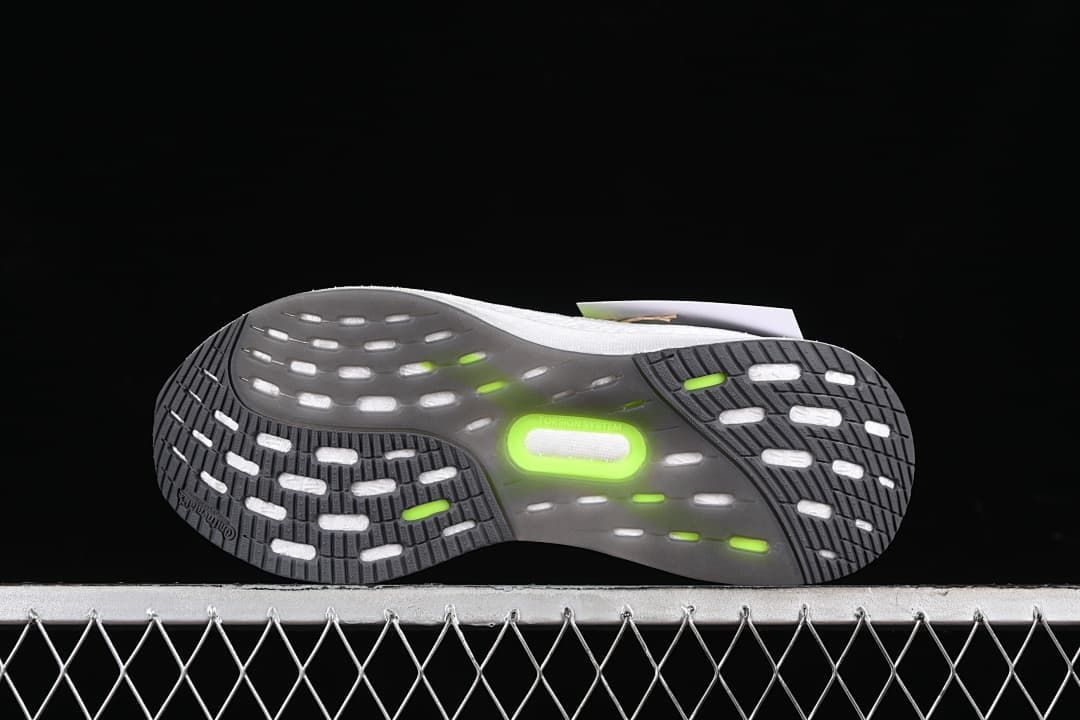 Underside view showing the patterned dark outsole with light and lime details.