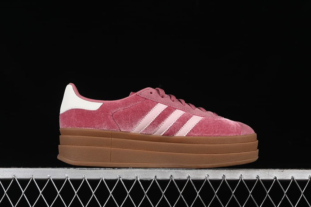 Side profile showing the pink upper, pale stripes, and layered platform sole