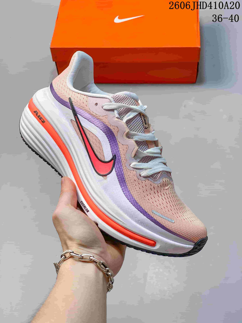 Side view of a pale pink Nike Air Zoom Winflo 12 shoe with purple and orange details.