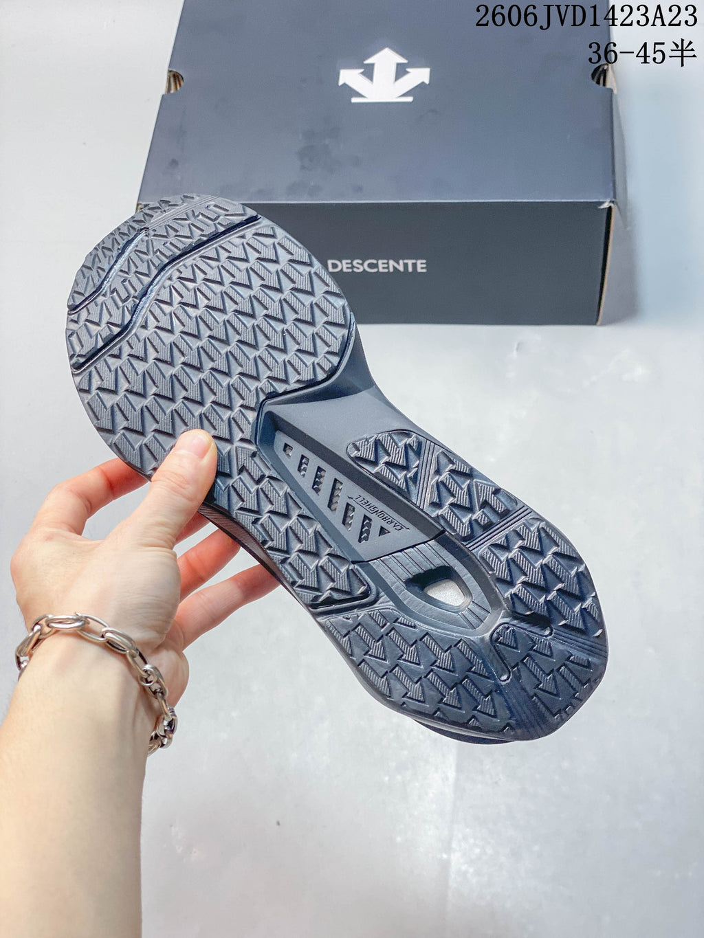 Close-up of the patterned outsole on a charcoal sneaker.