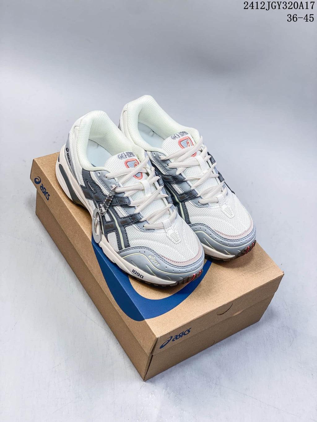 Pair of white and grey ASICS Gel-1090 sneakers shown on a shoebox
