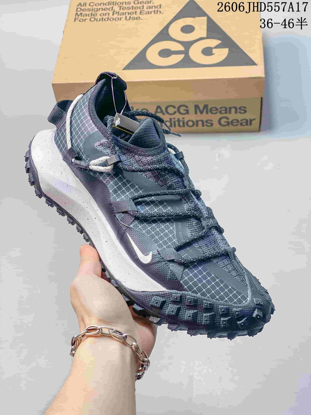 Nike ACG Mountain Fly sneaker in dark blue and gray with a patterned upper and lugged outsole.