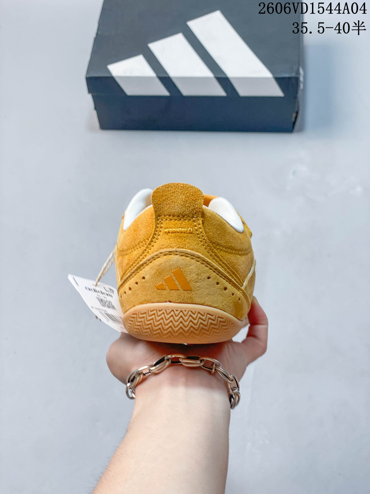 Rear view of a golden yellow low-top sneaker with heel branding and patterned outsole.