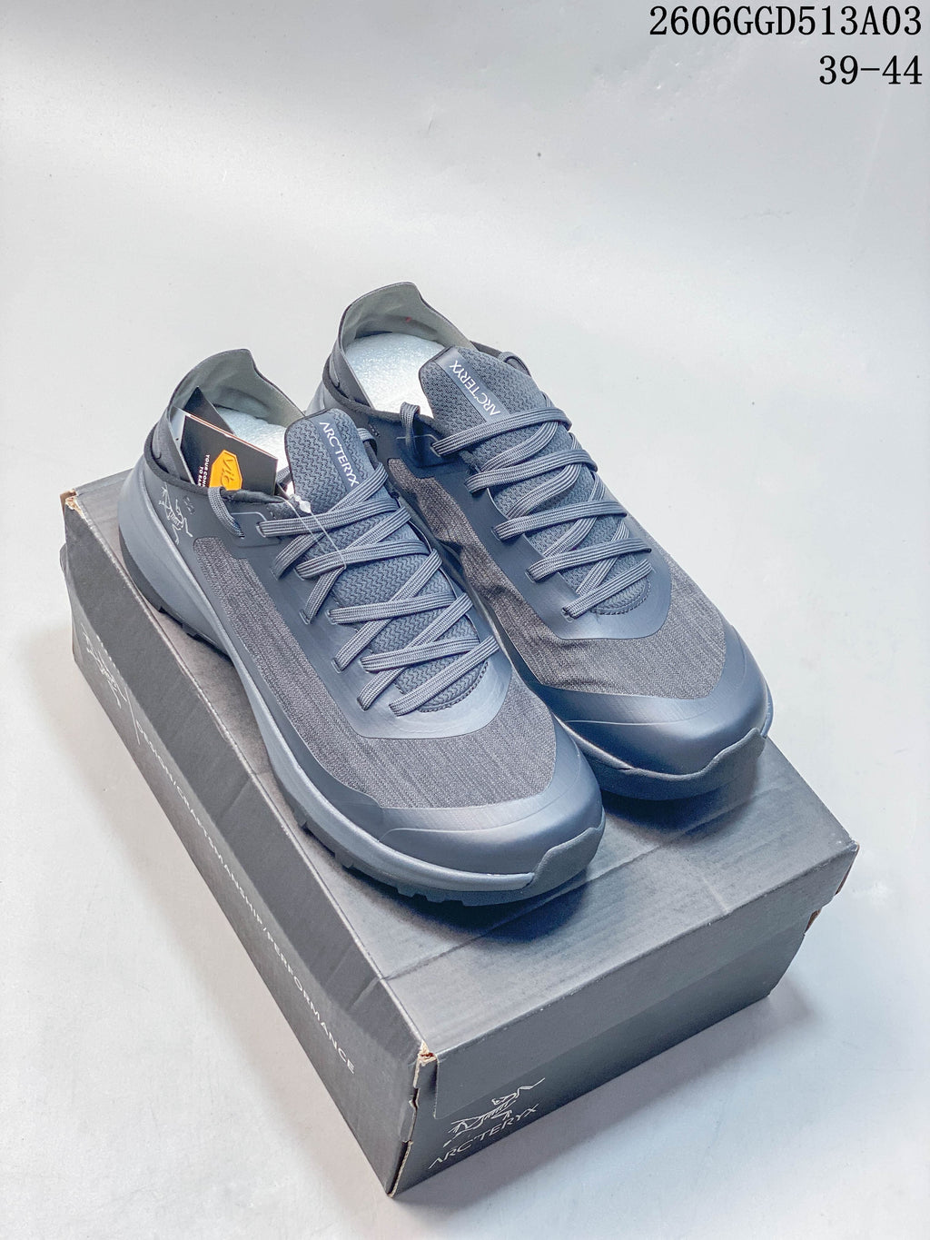 Pair of gray-blue Arc'teryx Konseal SL 2 low-top outdoor shoes displayed on a shoebox.