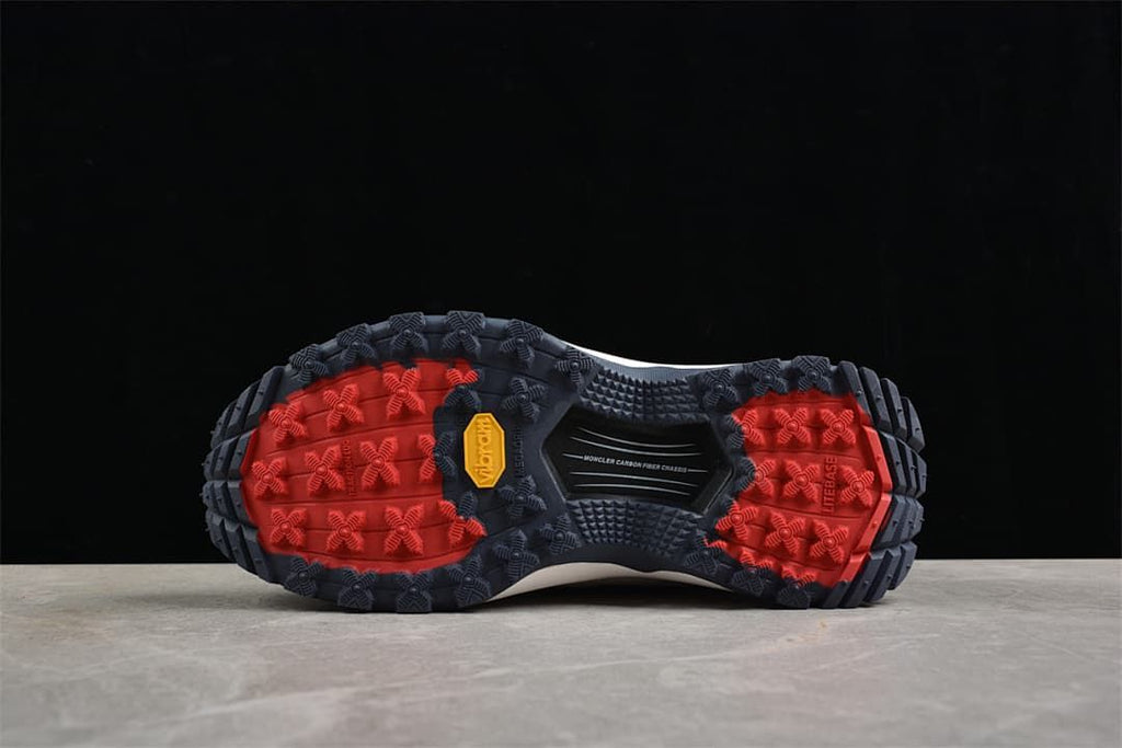 Underside view of the patterned outsole with navy and red sections.