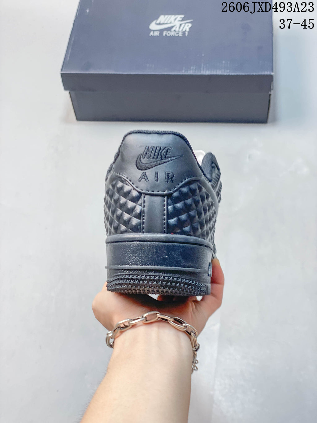 Rear view of a dark sneaker with embossed side panels and Nike Air branding