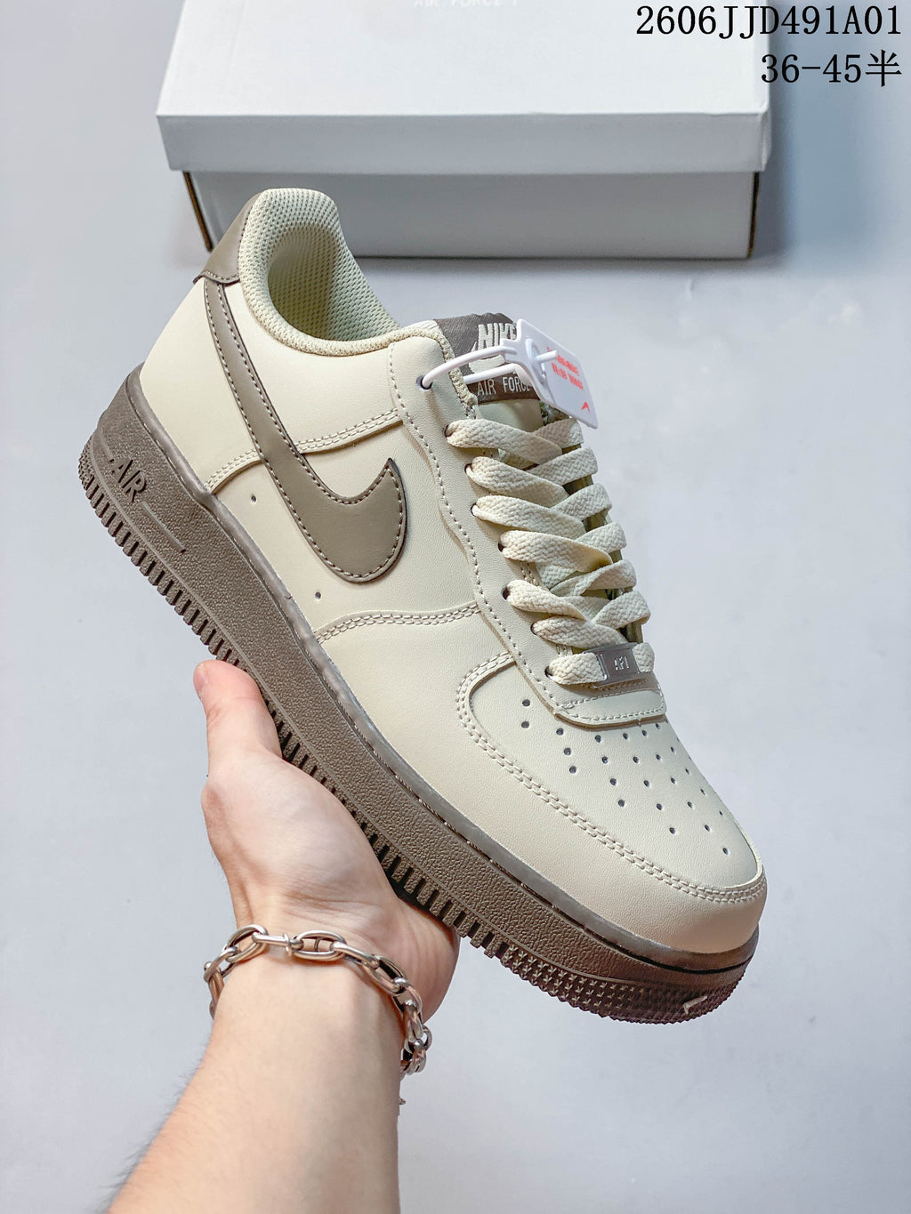 Angled close-up of the cream sneaker with taupe accents