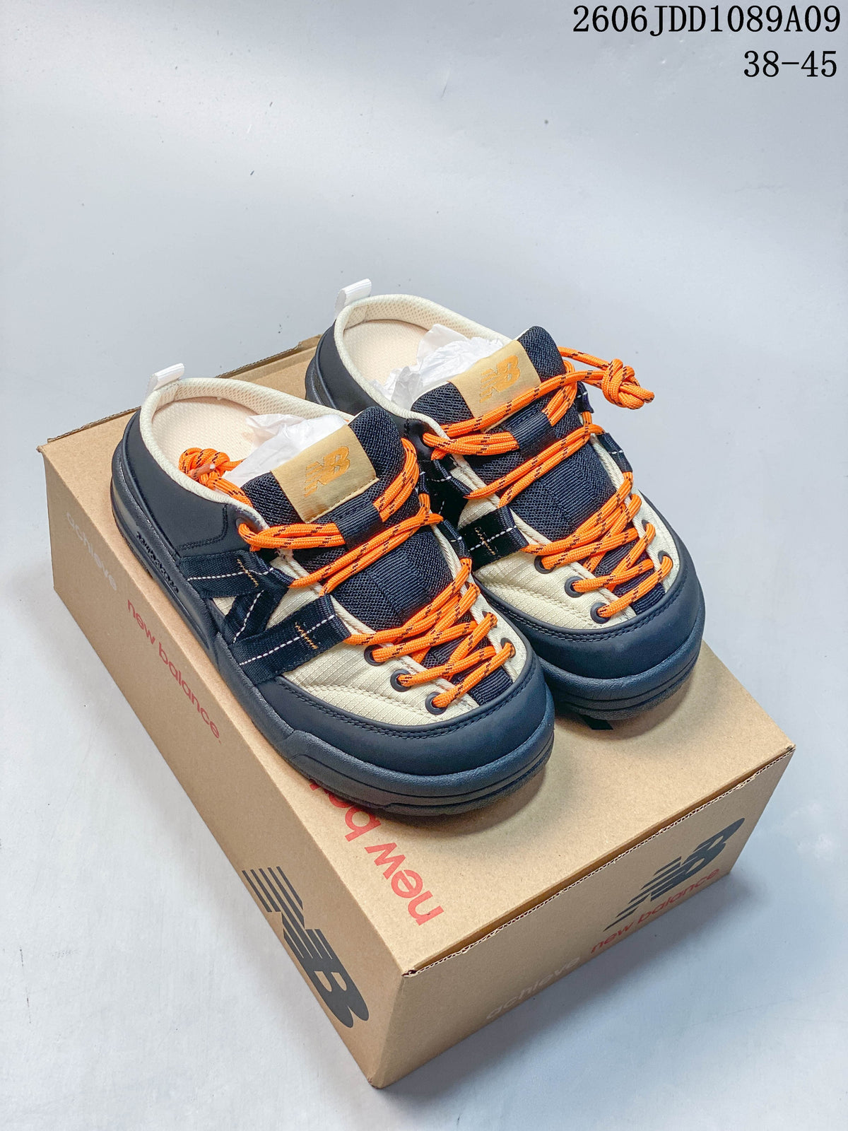 Navy and cream New Balance Terrace Mule shoes with bright orange laces.