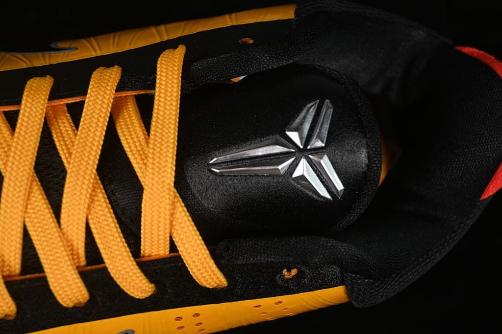 Close-up of yellow laces and Kobe emblem on the tongue