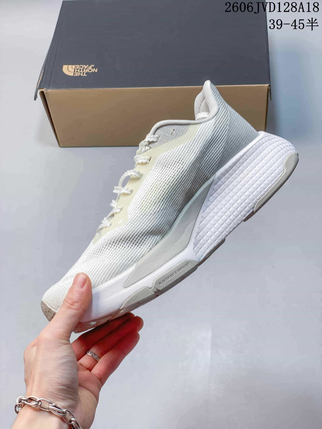 Side profile of a light-colored lace-up running shoe