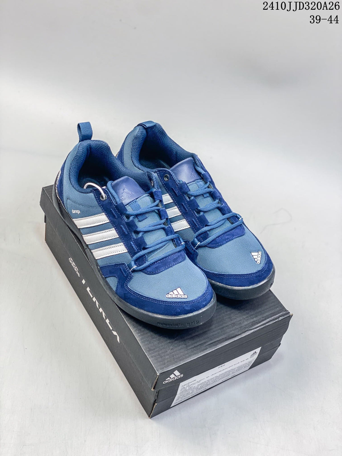 Blue adidas Daroga Plus Canvas shoes with white stripes, shown as a pair on a shoebox.