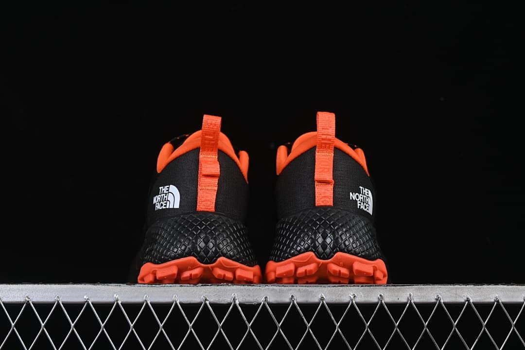 Rear view of the pair, with orange pull tabs and lugged outsoles.