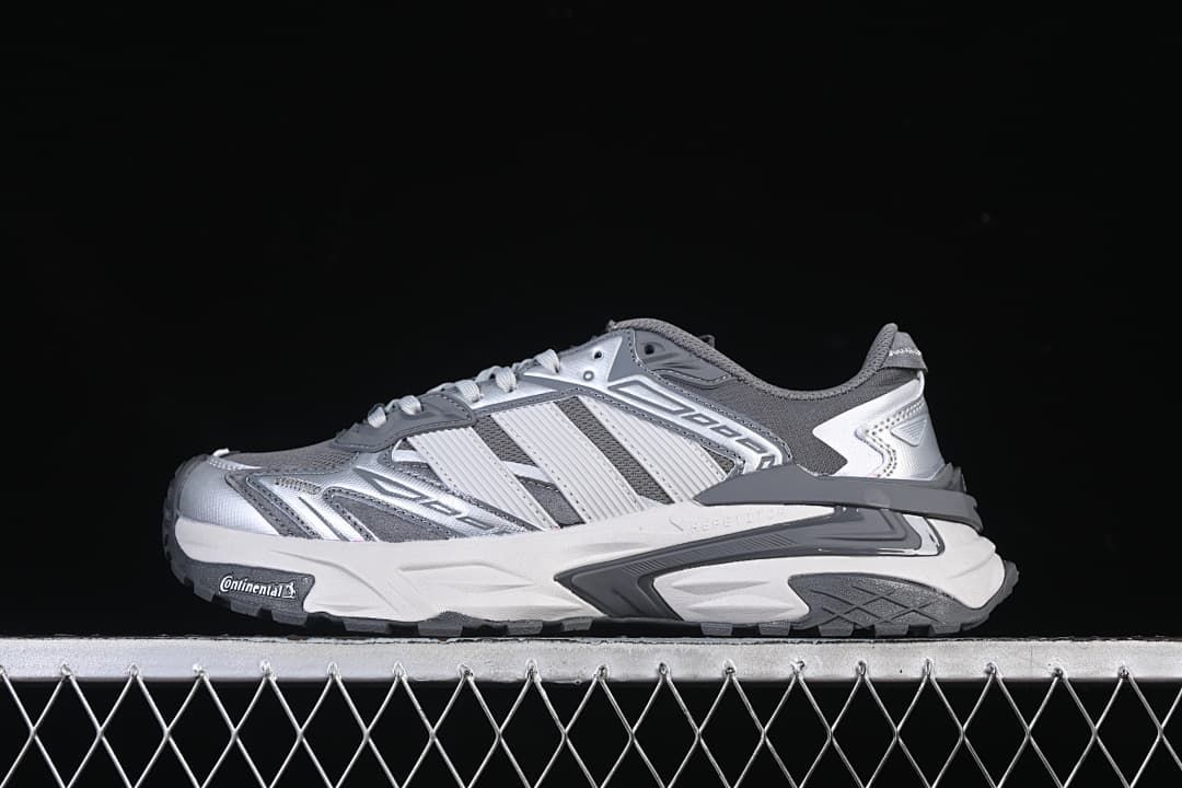 Side profile of the silver and gray sneaker against a dark background.