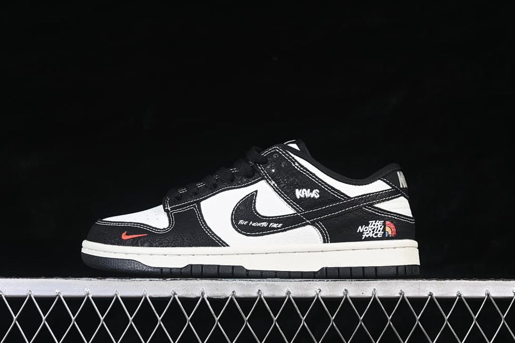 Side view of black and white low-top sneakers with contrasting stitching and graphic details