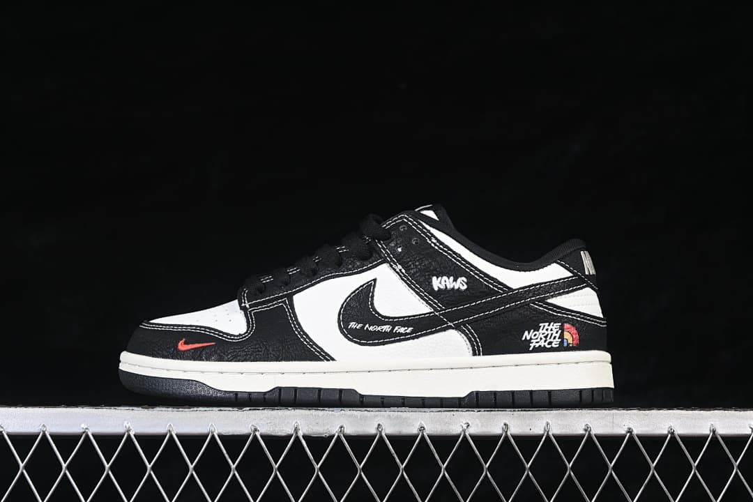 Side view of black and white low-top sneakers with contrasting stitching and graphic details