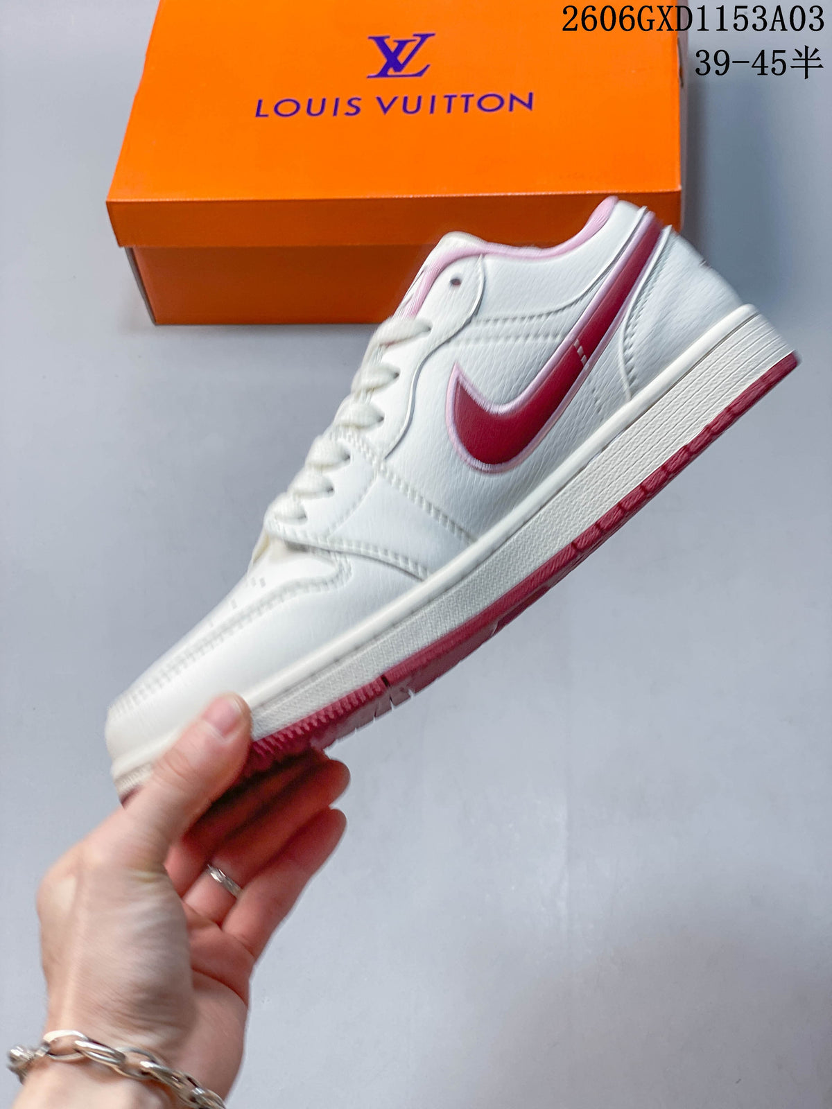 Side profile of a white low-top sneaker with pink side detailing and a pink outsole.