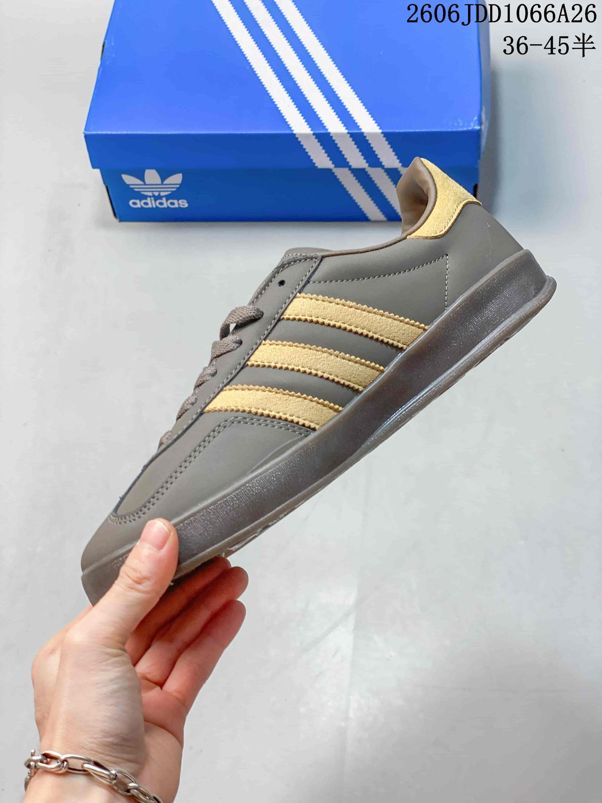 Side view of a grey low-top sneaker with gold-tone stripes