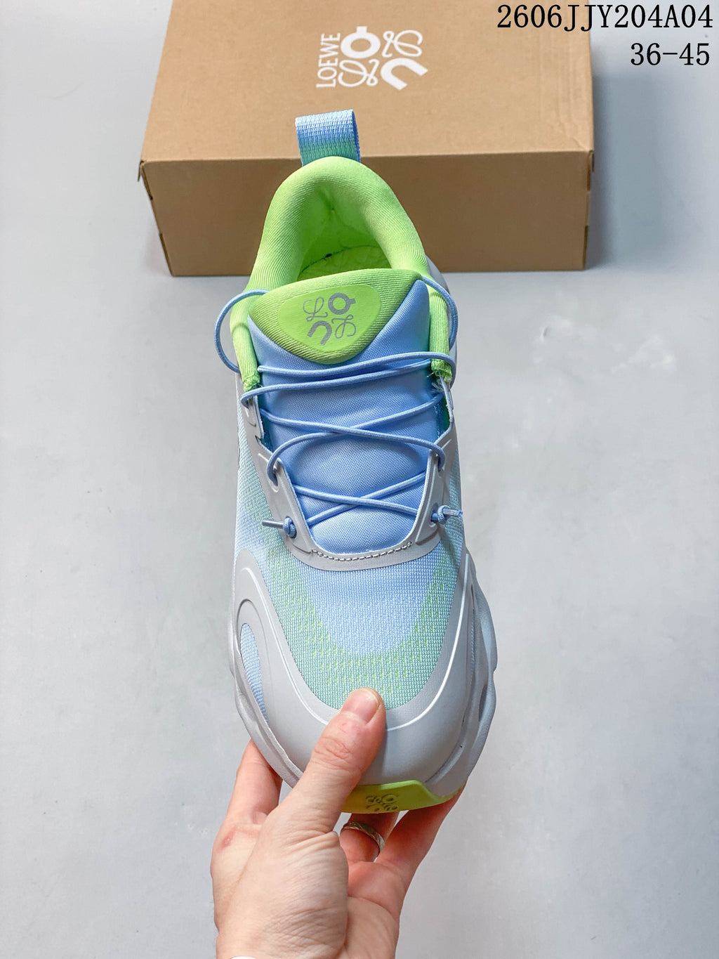 Top view of a sneaker showing elastic lacing, blue tongue, and pale green padded collar.