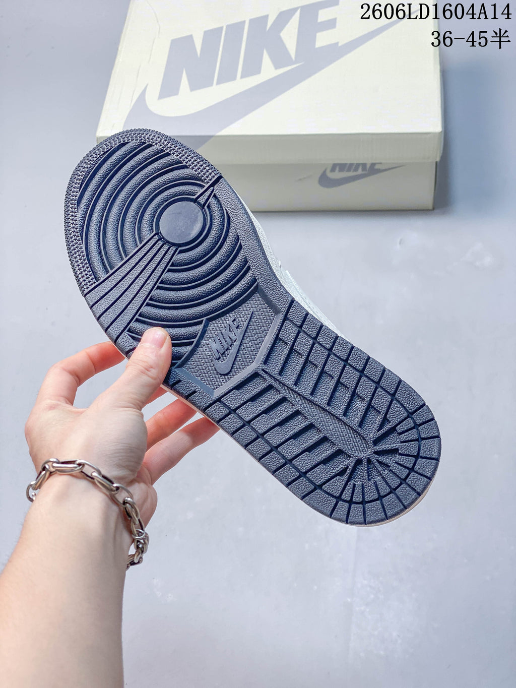 Close-up of the navy outsole with circular tread and embossed branding