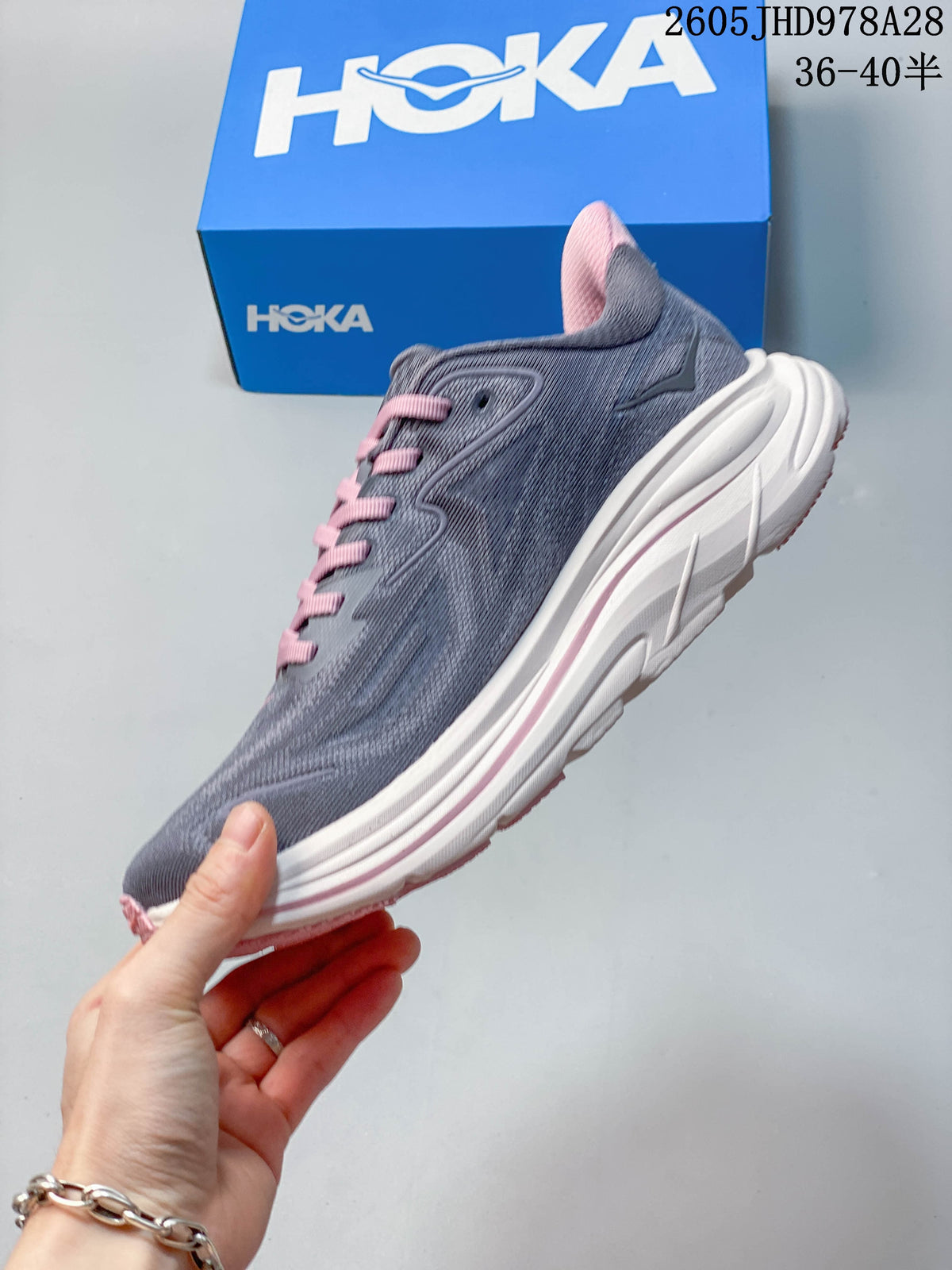 Side view of a gray HOKA Clifton 10 running shoe with a white midsole and pink laces