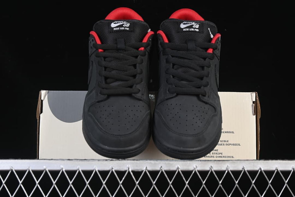 Front view of the pair of black sneakers resting on a shoe box