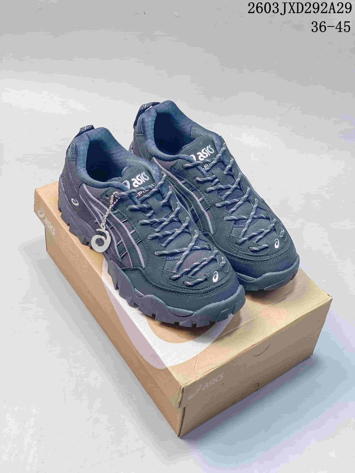Pair of dark grey ASICS Gel-Pickax sneakers on a shoebox