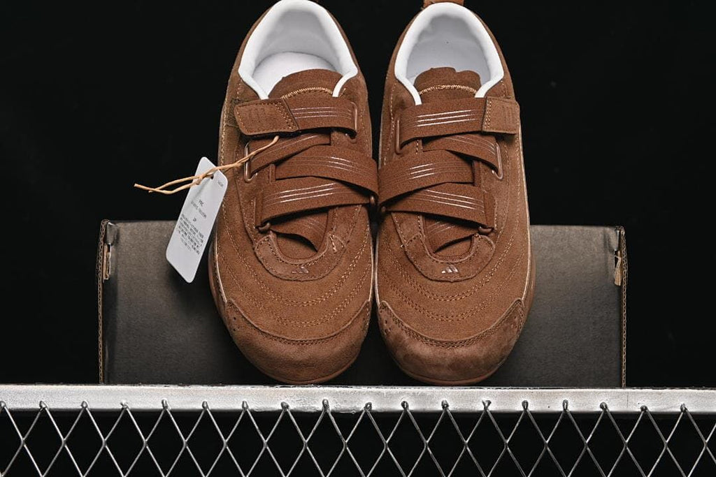 Pair of brown strap sneakers viewed from the front