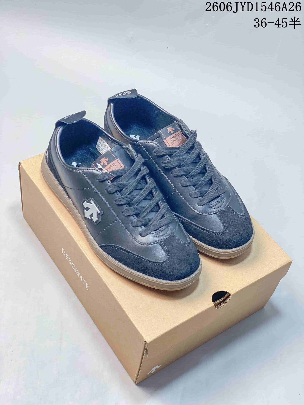Dark navy Descente low-top lace-up sneakers displayed on a shoe box.