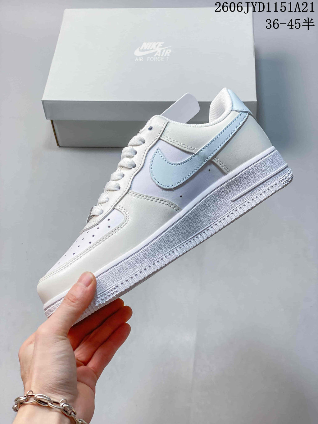 Side view of the white sneaker with a light gray Swoosh