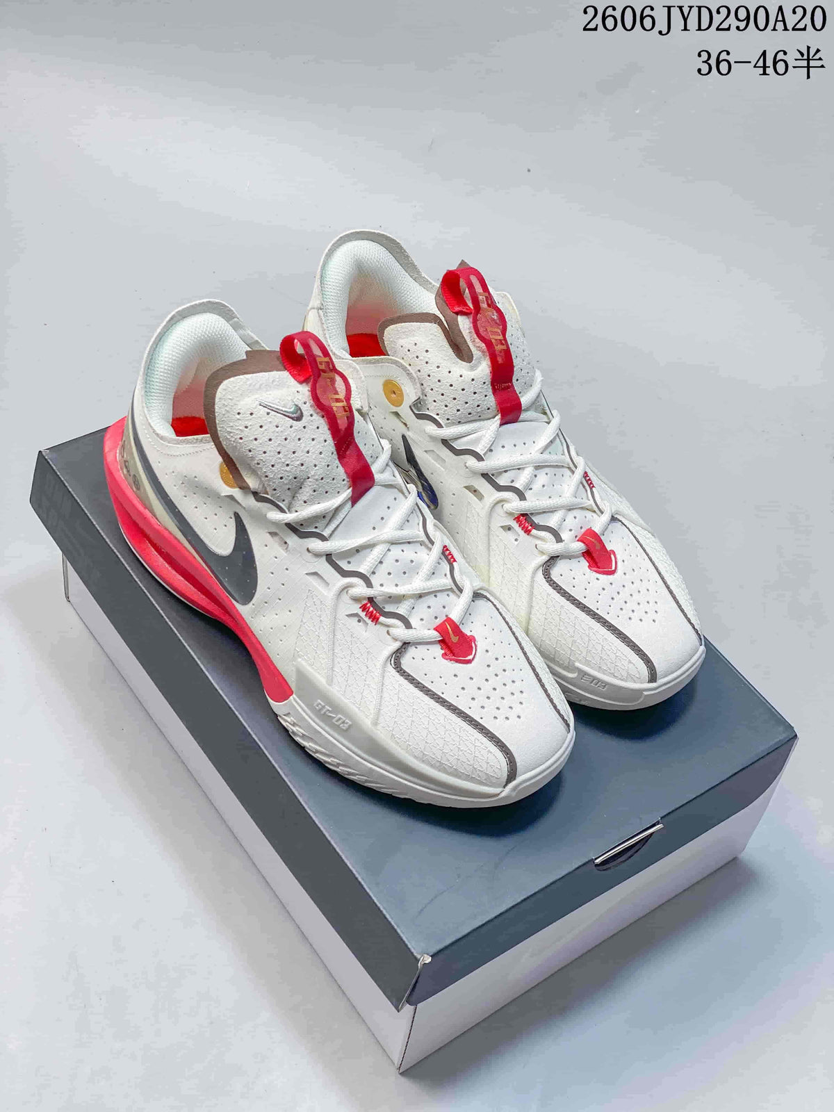 Pair of white Nike Air Zoom GT Cut basketball shoes with red accents on a box