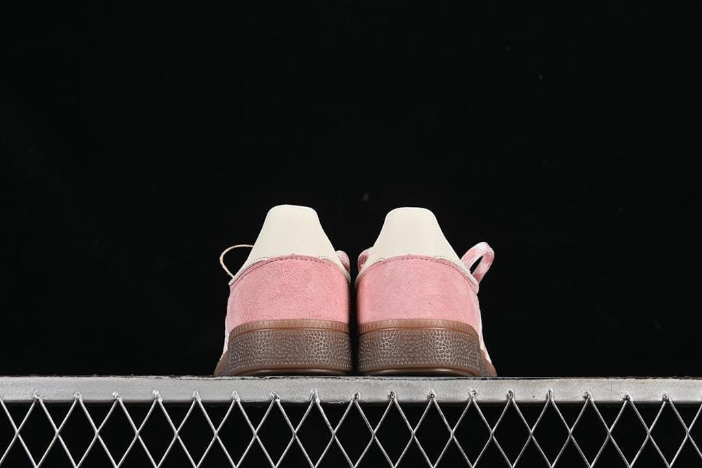 Rear view of both sneakers showing their pink heel panels and gum-colored soles