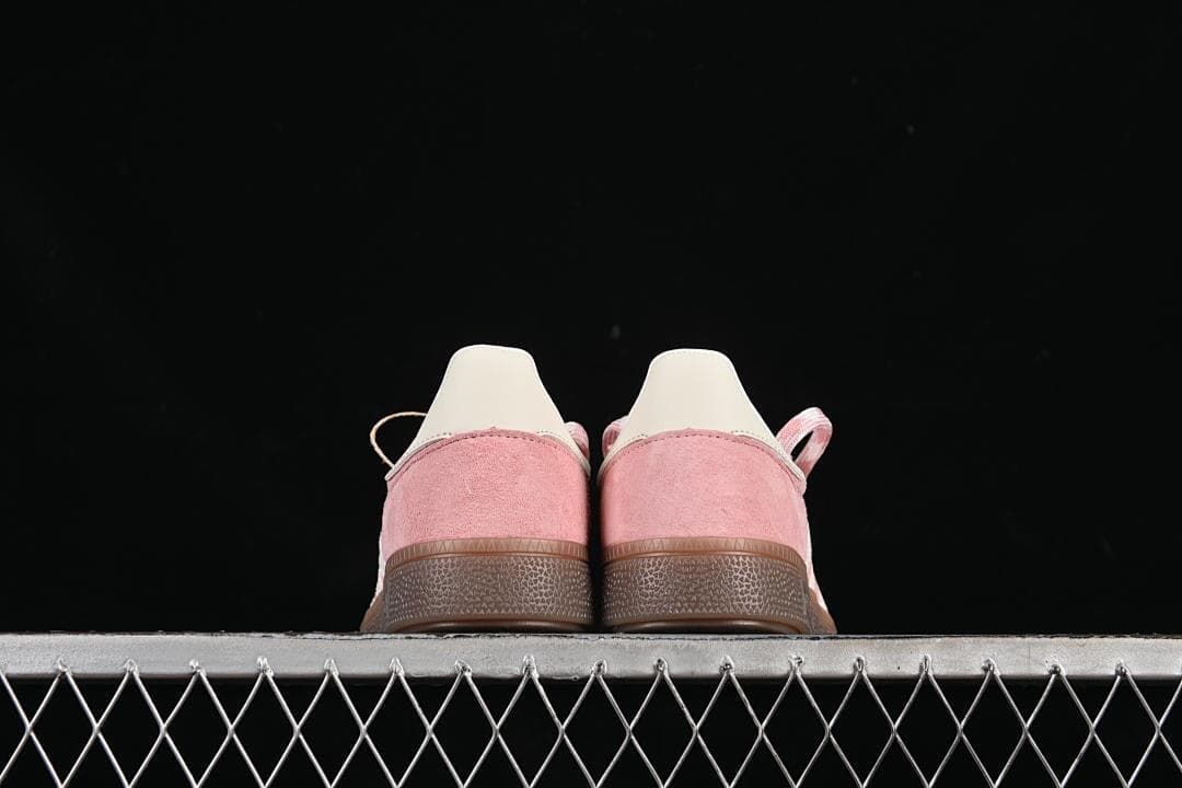 Rear view of both sneakers showing their pink heel panels and gum-colored soles