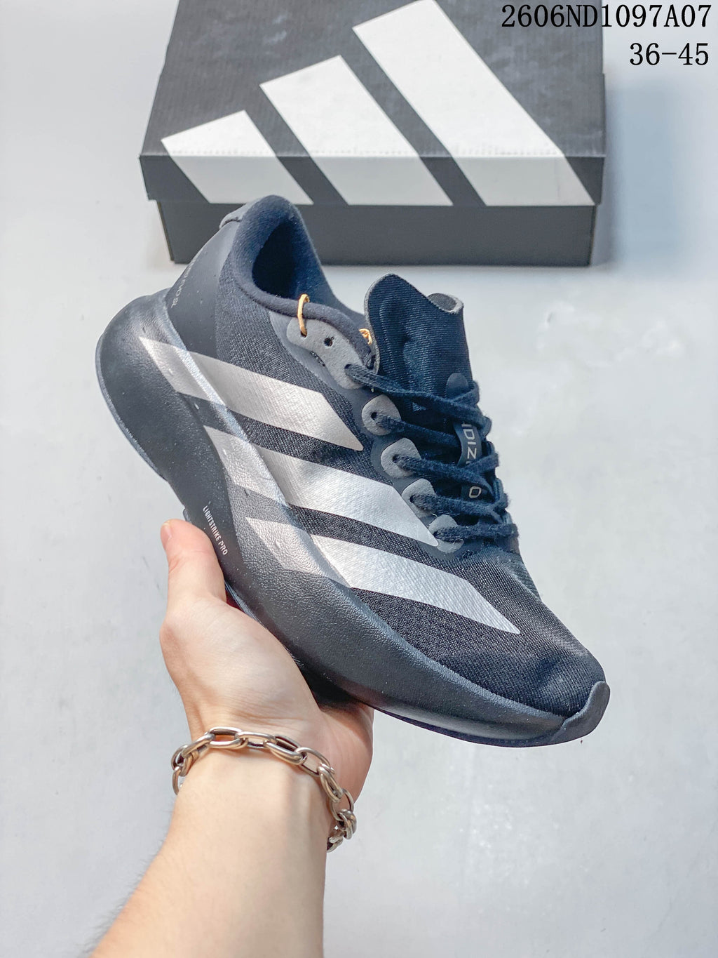 Angled side view of a dark gray adidas Adizero Evo SL shoe with silver-tone stripes.