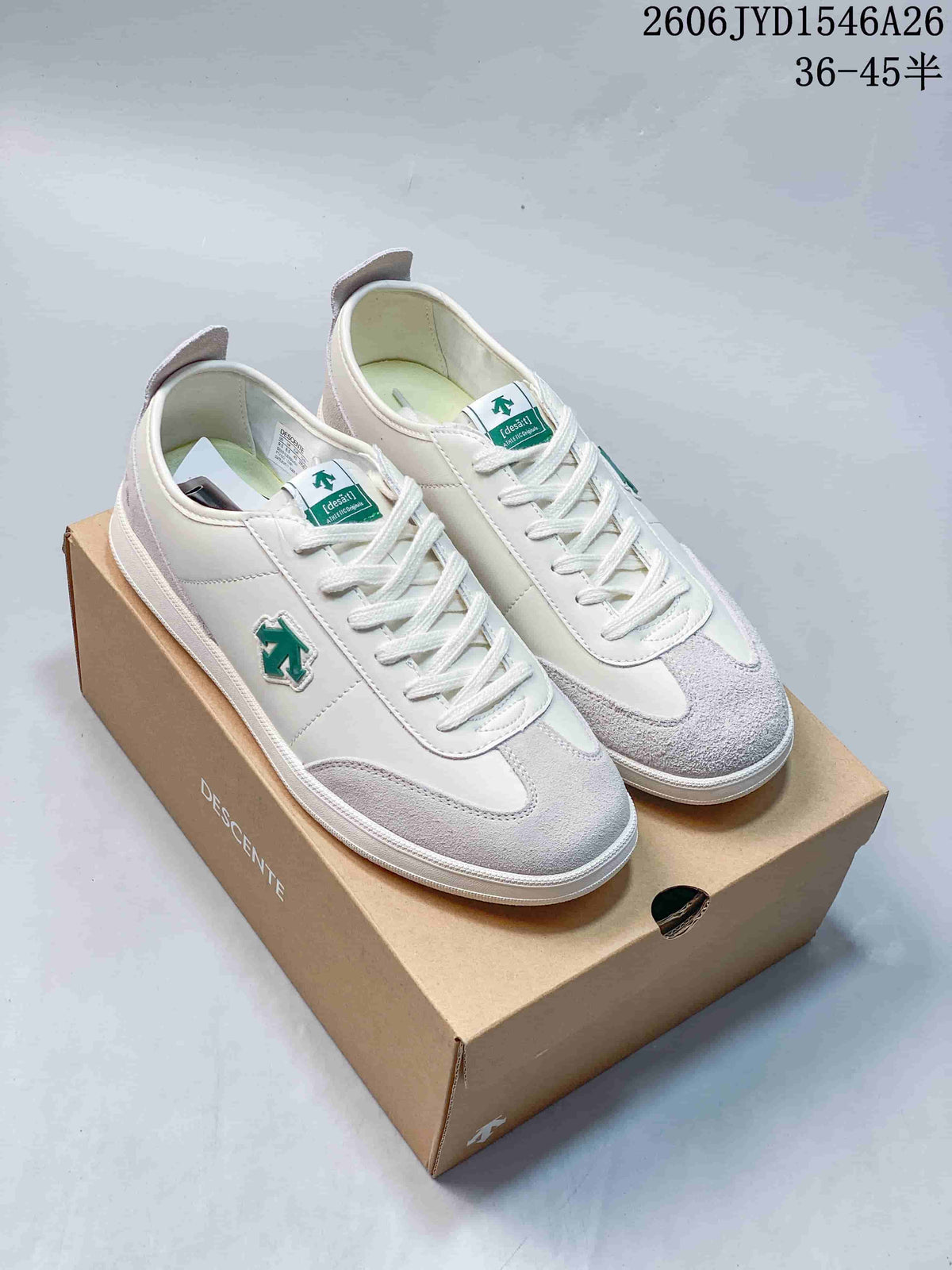 White sneakers with pale gray overlays and green accents displayed on a shoe box.
