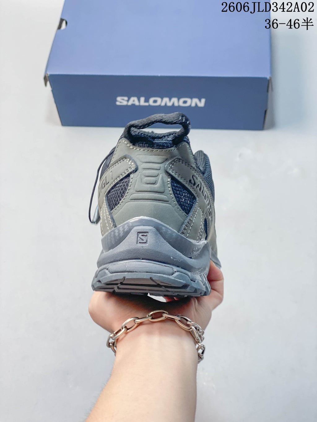 Rear view showing the heel structure and outsole of a gray Salomon trail shoe.
