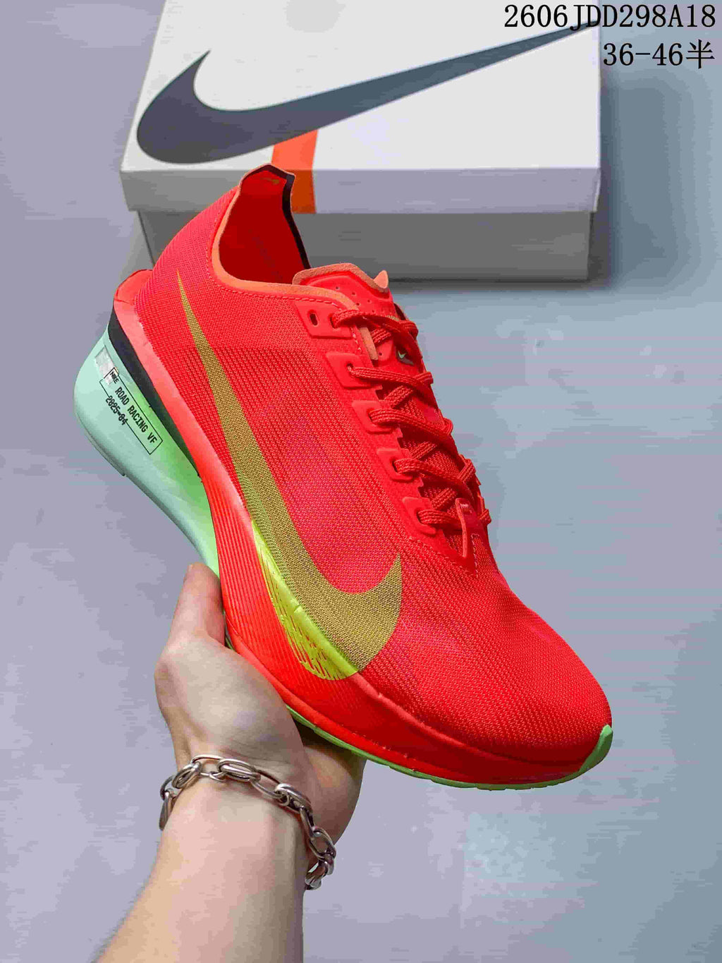 Side view of the red shoe with gold-toned side accent and green outsole details