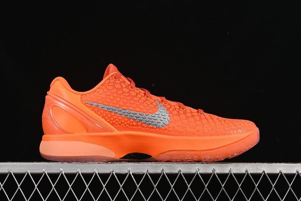 Side profile of orange shoe with metallic silver Swoosh