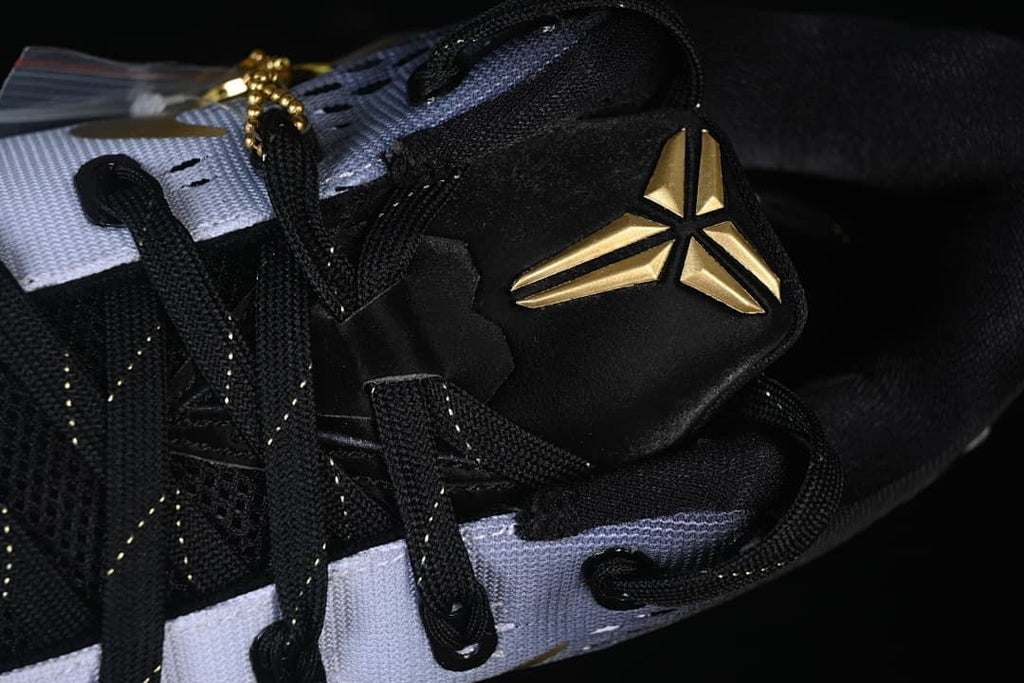 Close-up of black laces and gold Kobe logo on the tongue