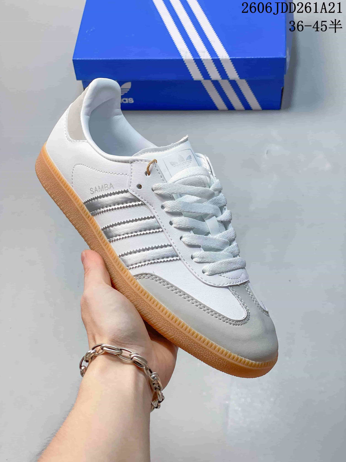 Close-up of a white adidas Samba shoe with silver stripes and a gum-colored sole.