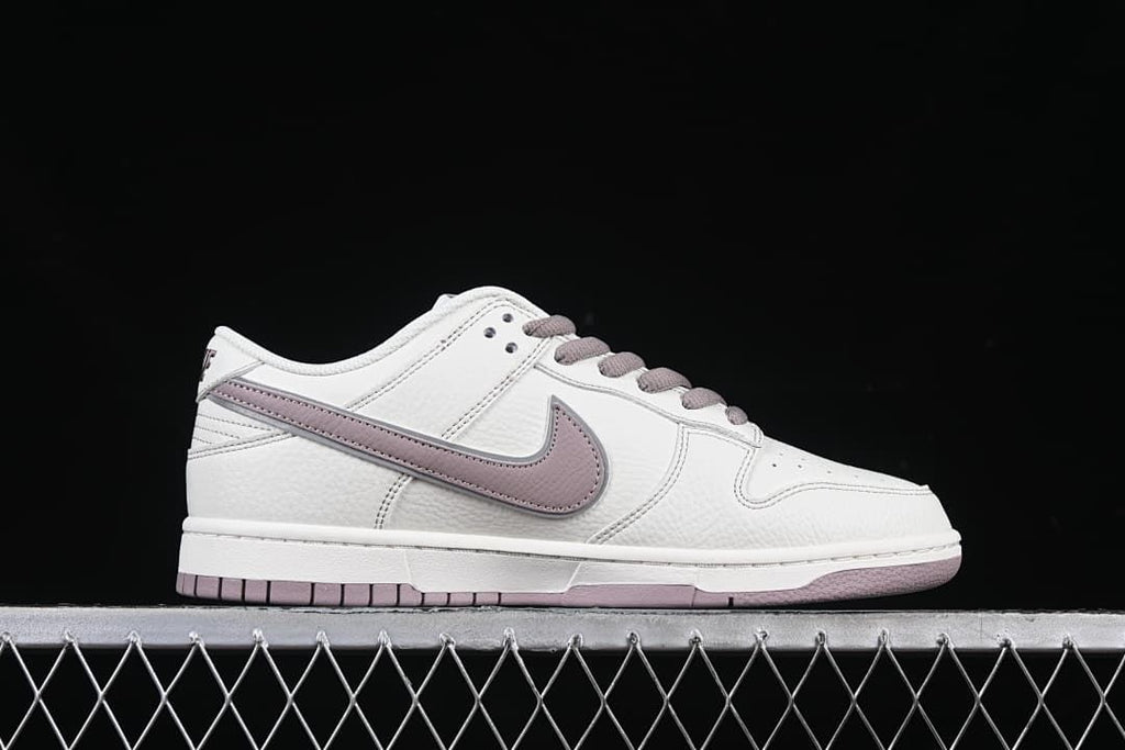 Outer side profile of a white low-top sneaker with mauve Swoosh and outsole accents