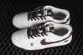 Pair of white low-top sneakers with burgundy laces and Swooshes, gray patterned side panels, and graphic details.