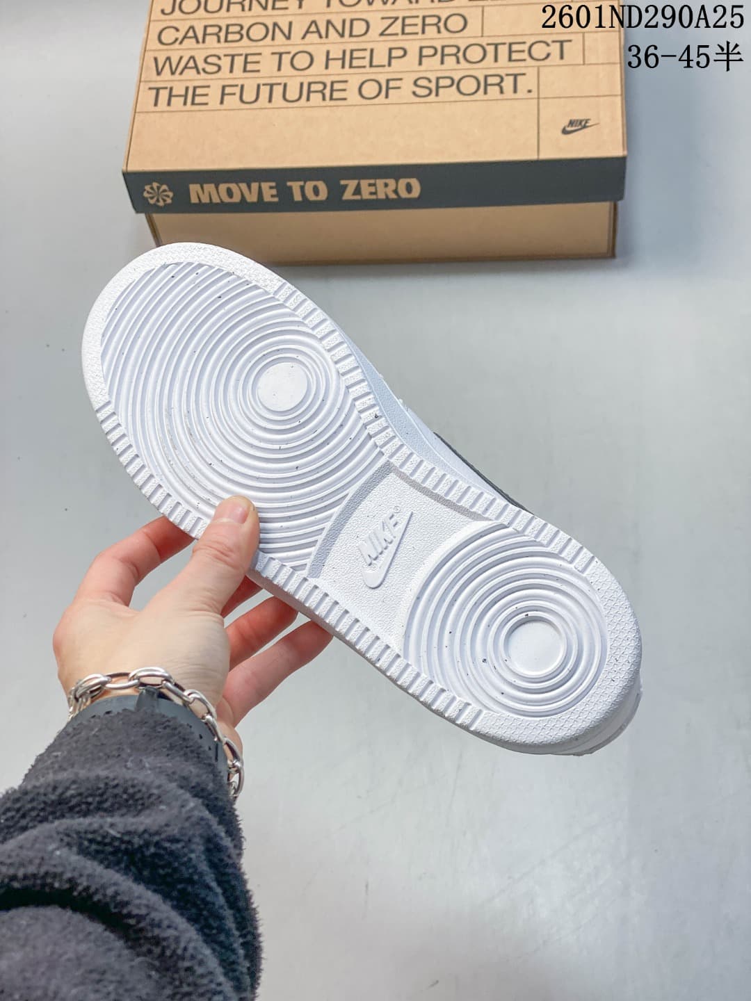 Underside of a white sneaker showing its circular-patterned outsole