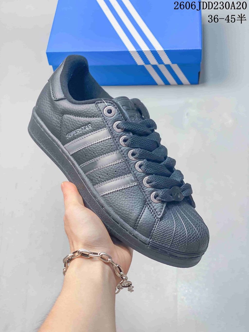 Angled side view of the dark gray Superstar sneaker